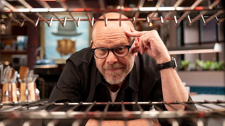 Food Network chef Alton Brown looking into oven.