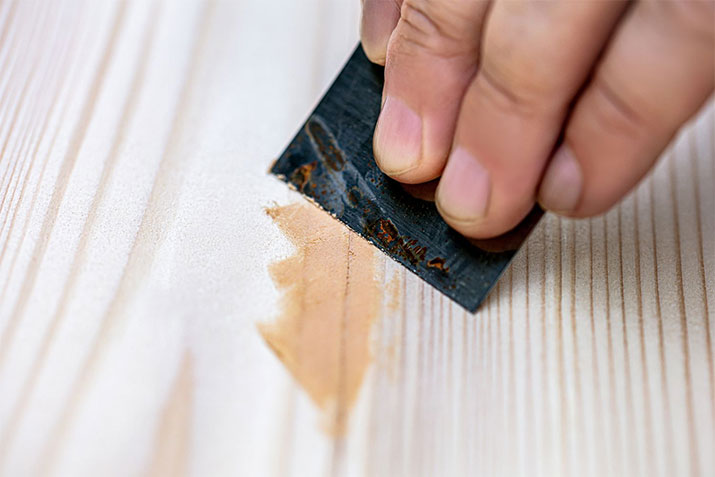 Applying wood filler during a woodworking project.