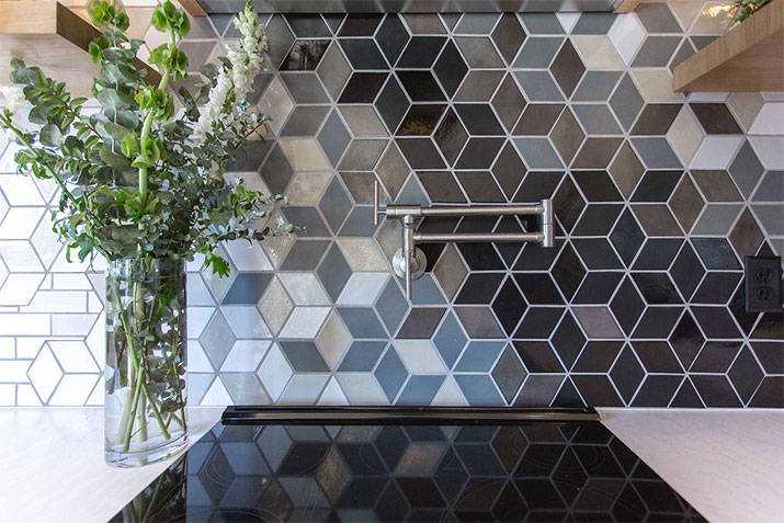 Backsplash tile design in varying contrasting shades and with white grout.