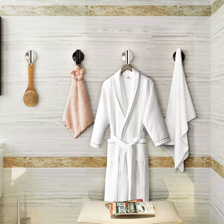 A loofah, towel, and a bathrobe hanging on bathroom hook