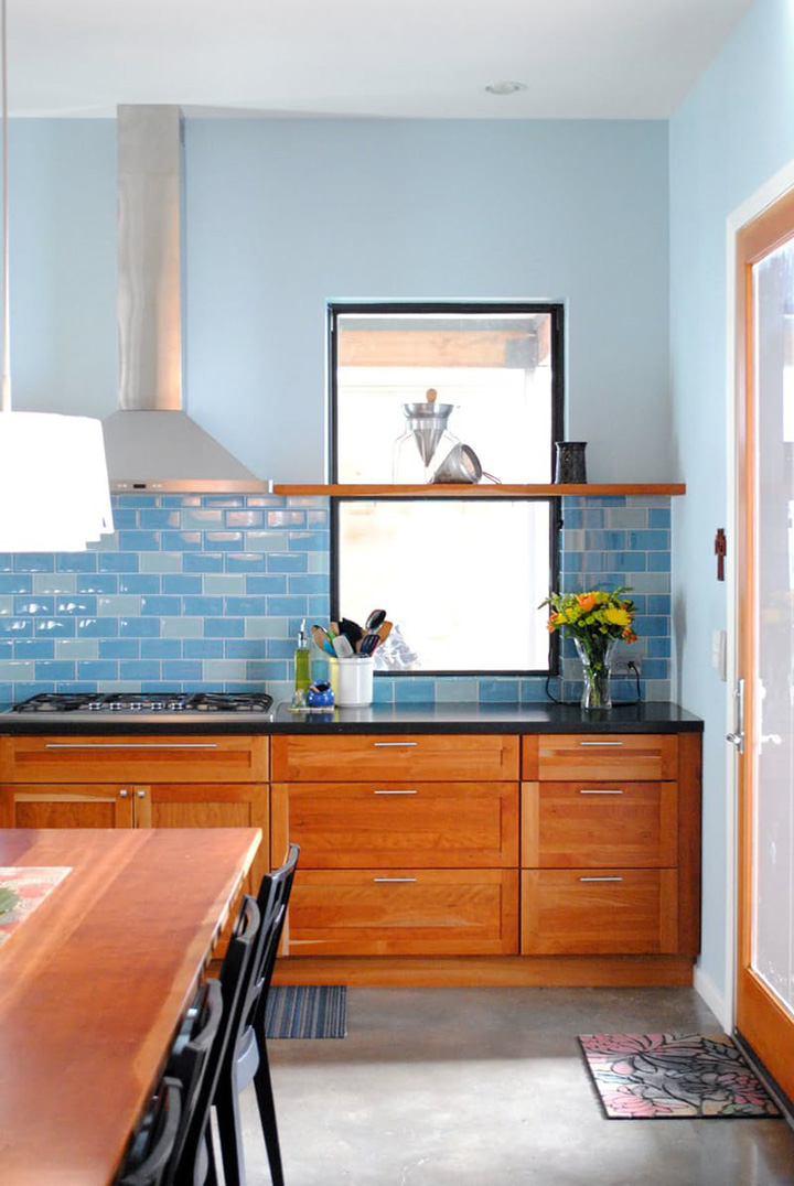 Blue walls, blue tile backsplash, finished wood cabinet drawers