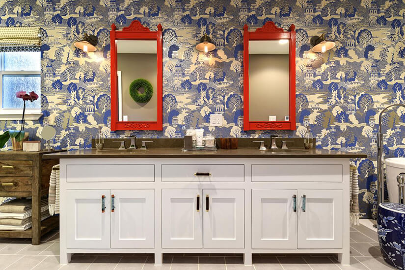 This bathroom uses bold wallpaper in bright blue and gold that depicts a nature scene.