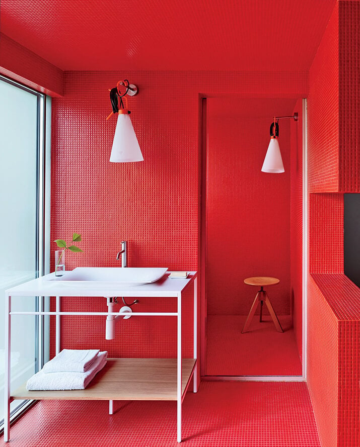 Bright red tiles cover every part of this bathroom.