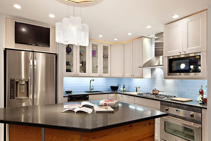 Brightly lit kitchen with undercabinet lighting and recessed lighting.