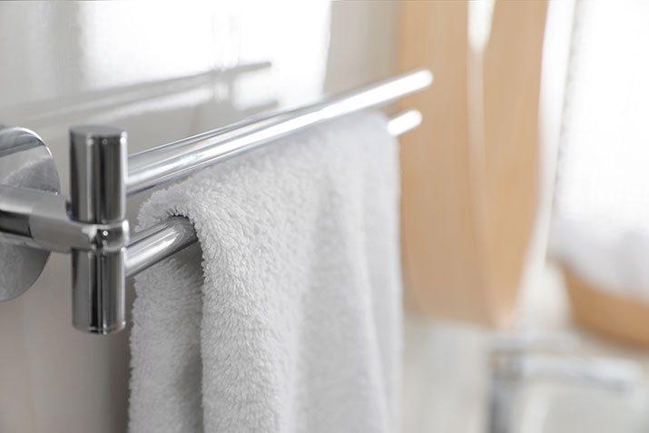A classic towel bar holding a white towel.