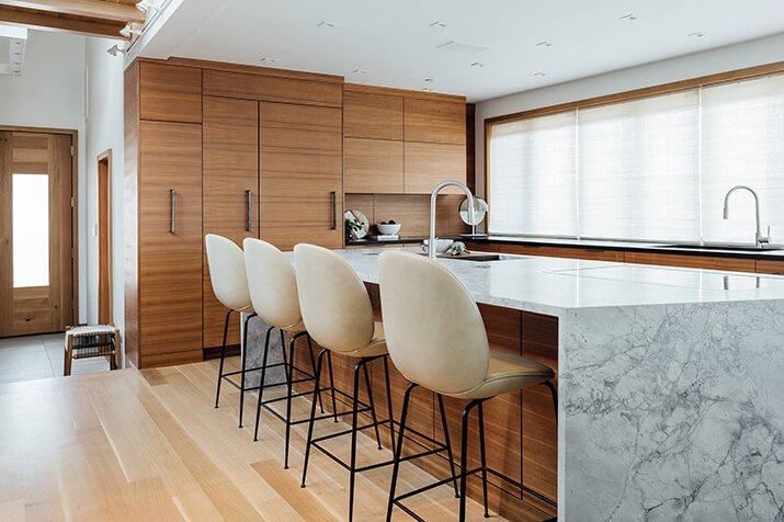 Contemporary kitchen with flat paneled cabinets and a built-in refrigerator.