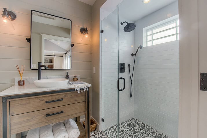 Curbless shower with beautiful black and white tile throughout bathroom.