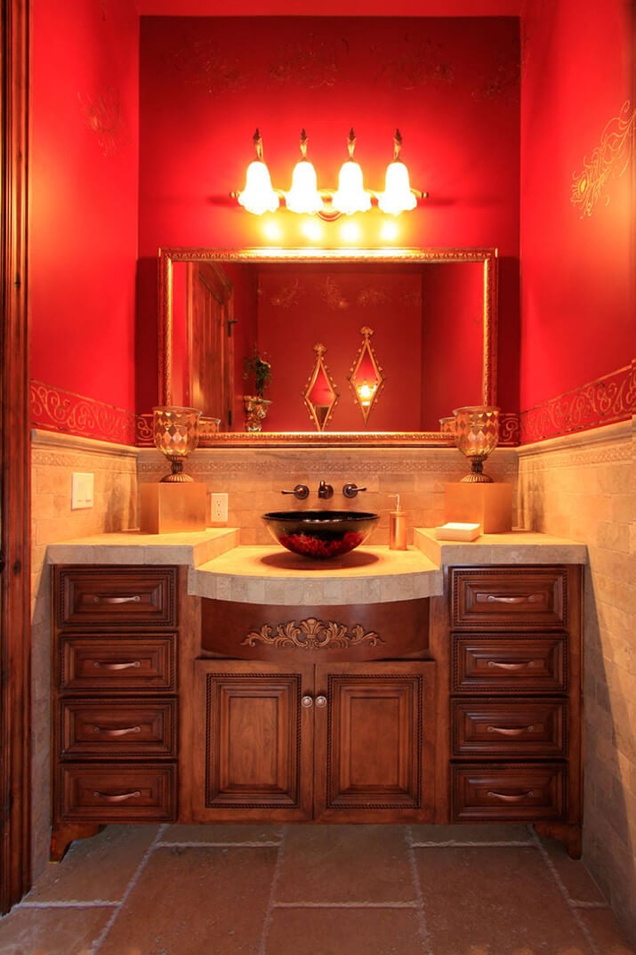 Deep red bathroom with warm lighting and stone floor.
