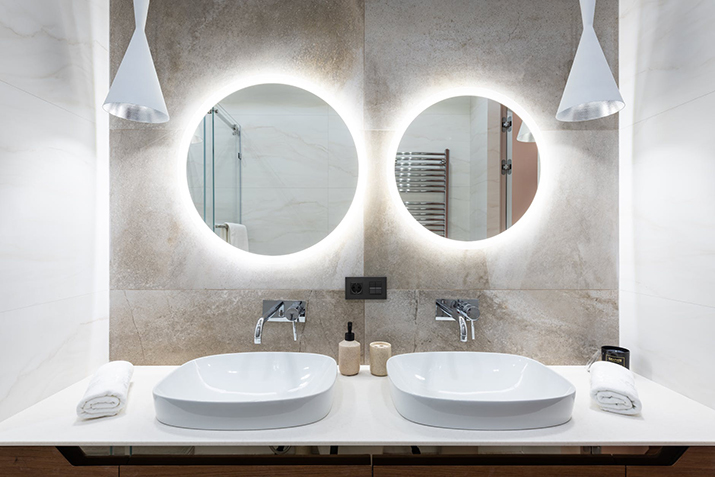 Bathroom vanity with backlit mirrors.