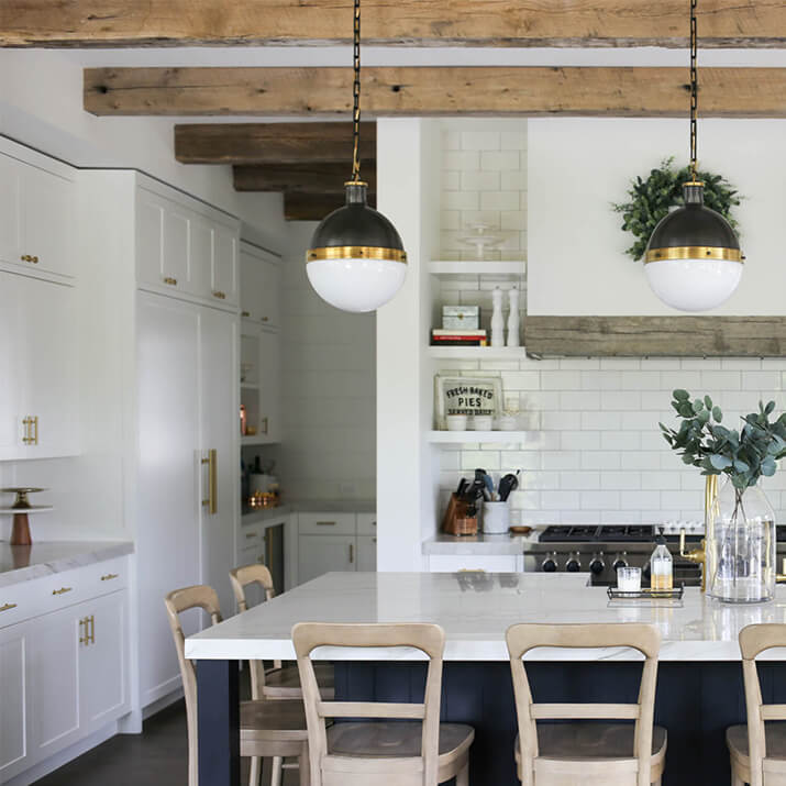 Farmhouse kitchen with wood ceiling beams and wood range hood.