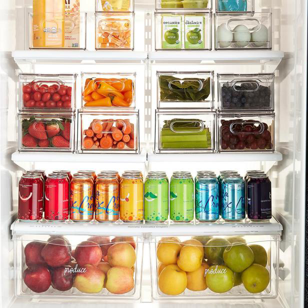 Fruits and vegetables organized in clear plastic bins in the refrigerator..