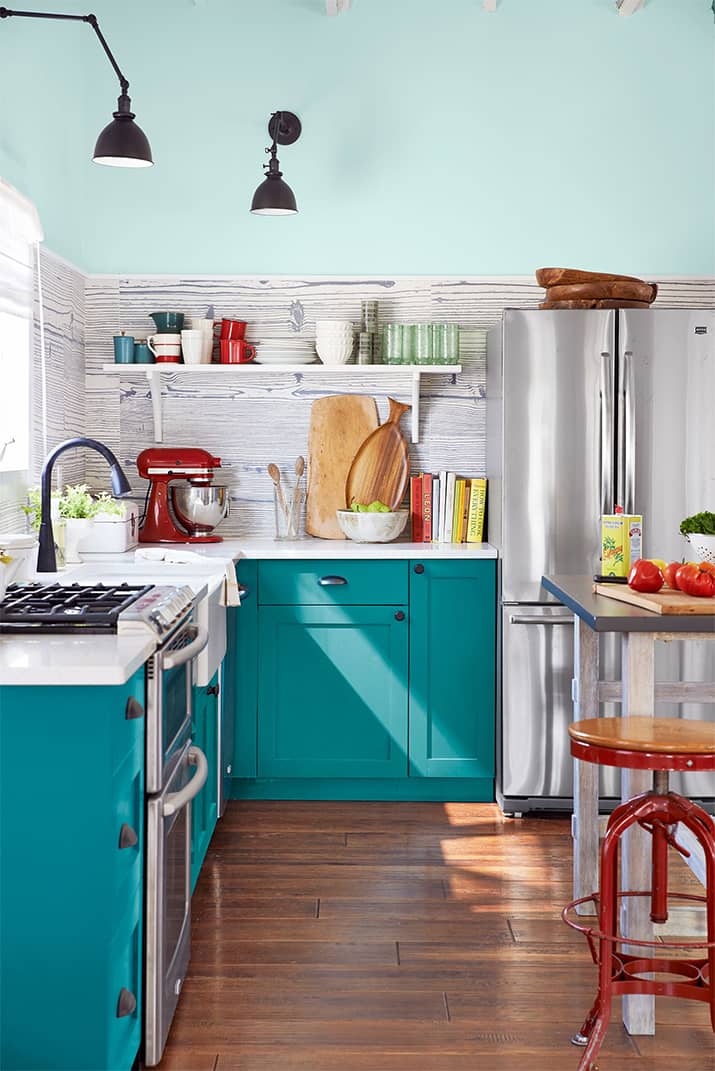 Funky kitchen with white countertops and teal kitchen cabinets.