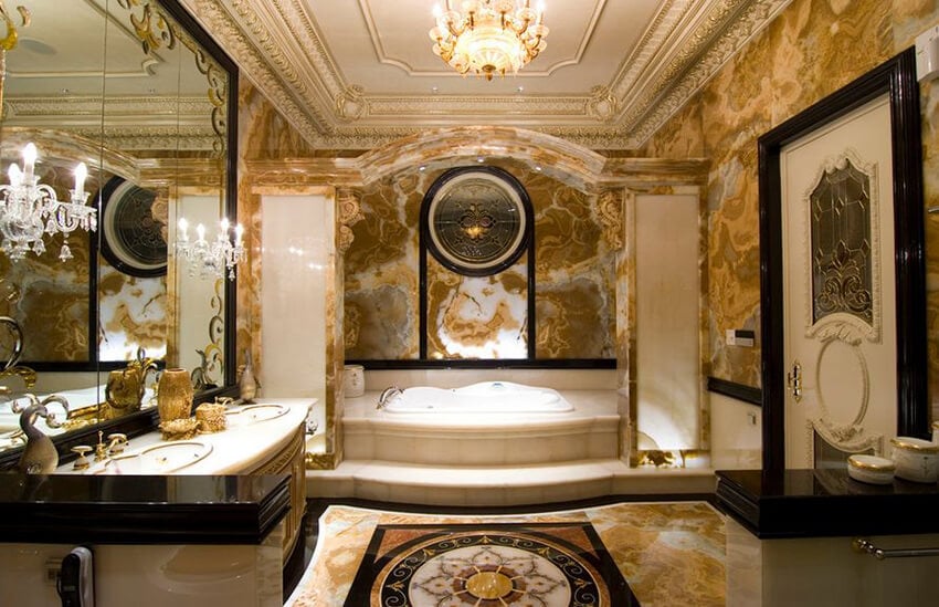 Decadent yellow and white marble encase this glamorous bathroom.