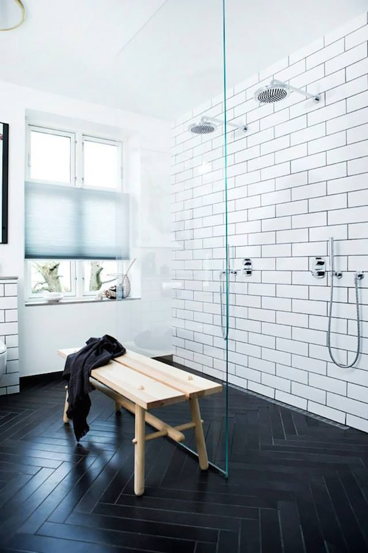 Glass shower wall, white subway wall tile, black fishbone floor tile, bench