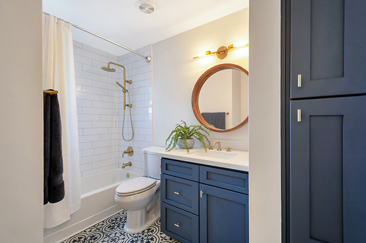Bathroom with bathtub, linen closet, and ample lighting.