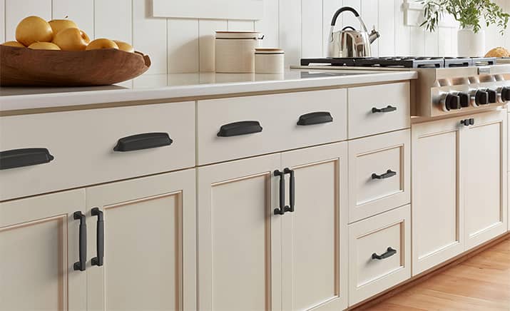 Kitchen with beige cabinets and matte black pulls and knobs.