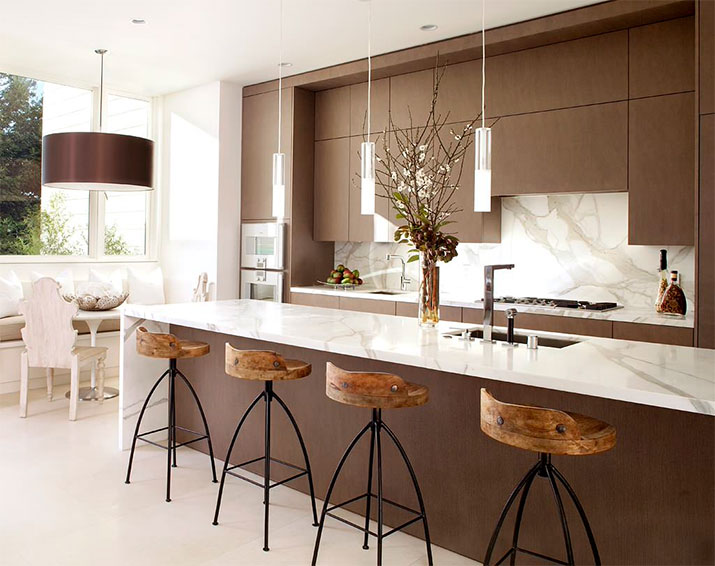 Kitchen with dark wood cabinets, marble countertops, and a stone slab backsplash.