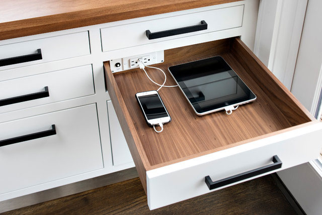 Kitchen drawer with built-in charging station charging a phone and iPad.