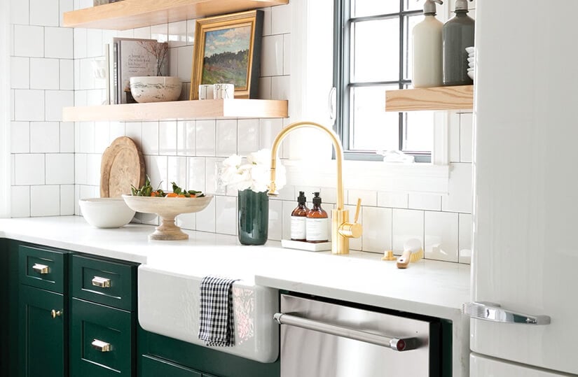 Kitchen with a gold sink faucet and chrome cabinet pulls.