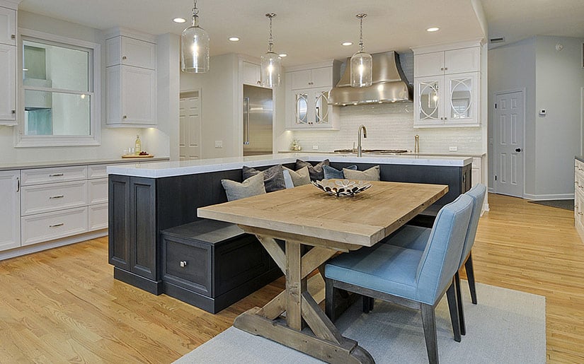 Kitchen island bench in an L shape with dark wood.