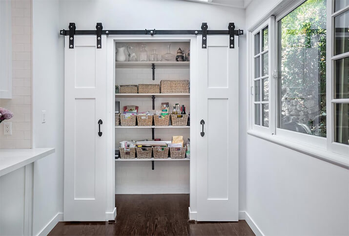 Kitchen pantry with two sliding barn doors.