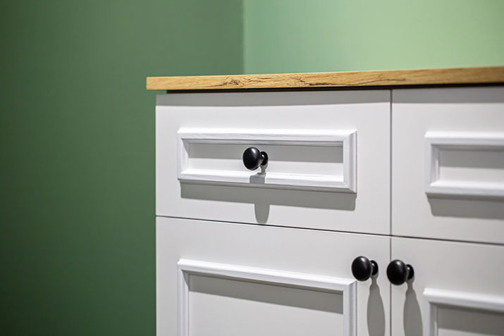 Knobs centered on kitchen cabinet drawers.