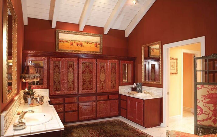 Large red bathroom with intricately patterned built-in cabinets.
