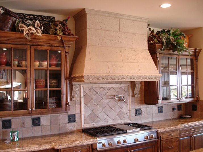 Large kitchen hood design with a tan tile facade.