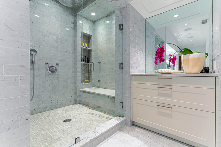 Large trendy gray master shower with built-in bench and shower niche.