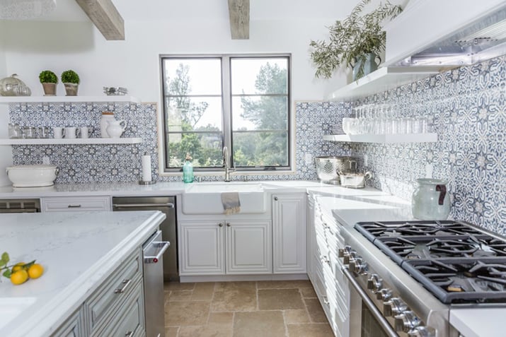 Light kitchen with tile backsplash that extends across two walls.