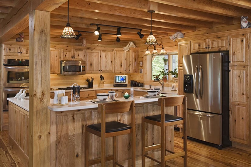 A log cabin kitchen with knotty pine cabinets.