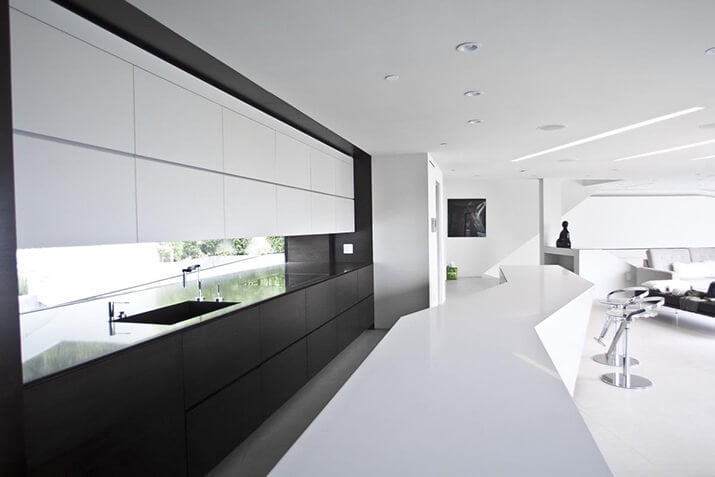 Long modern kitchen window backsplash below white upper cabinets.