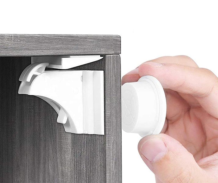 Opening a cabinet with a magnetic childproof cabinet lock.