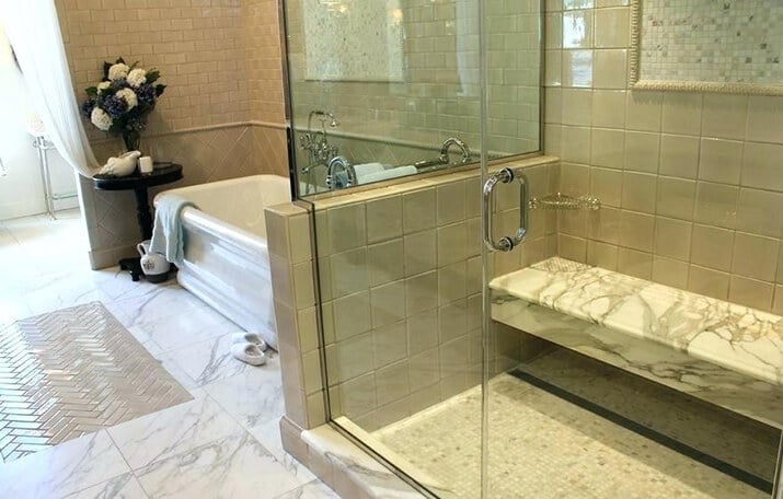 Marble floating bench in the shower matches marble from the rest of the bathroom.