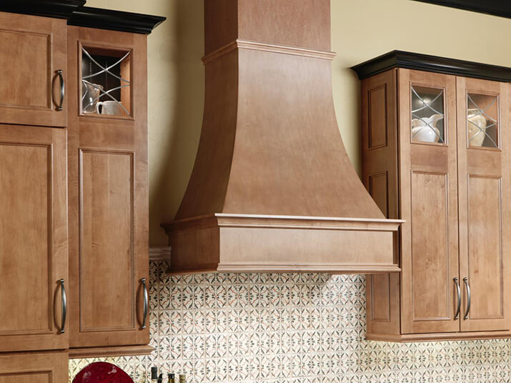 Medium natural wood kitchen hood design that matches the traditional cabinets.