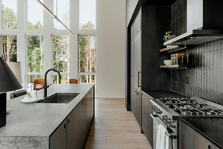 Modern black kitchen with white stools.