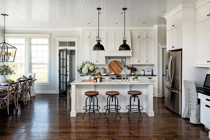 Modern farmhouse kitchen with black metal accents and white cabinets and countertops.