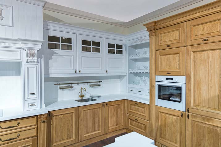 Light oak kitchen cabinets with white walls in a small kitchen.