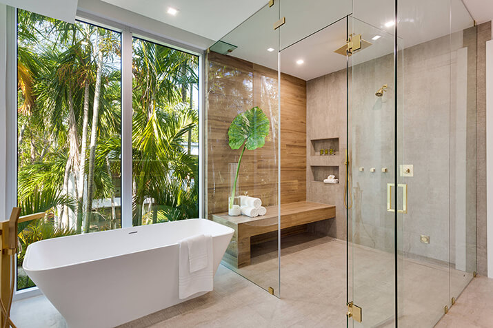 Open and airy bathroom with natural light featuring a shower bench and niche.