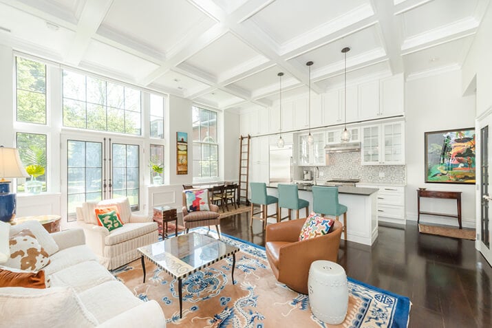 Open-concept living space with area rugs in the living room and dining room.