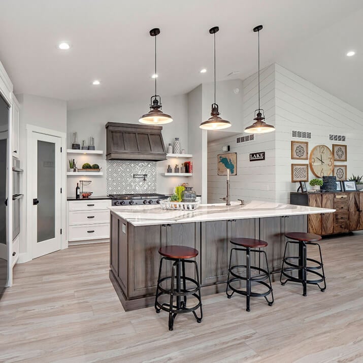 Open plan kitchen featuring shiplap walls and light gray wood floors.