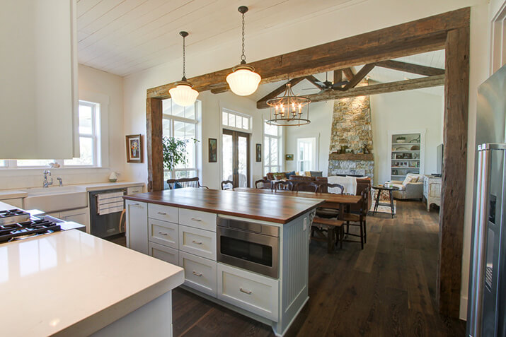 Open plan kitchen with a wood kitchen island that blends with wood architecture.