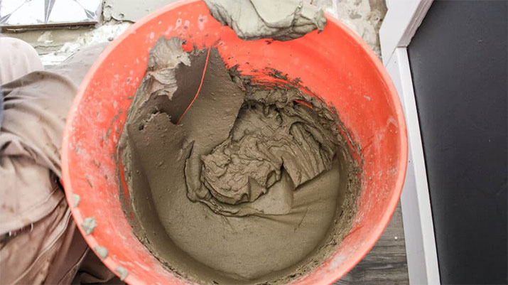 Orange bucket filled with mortar.