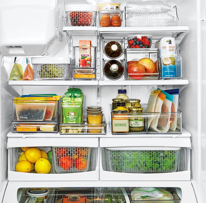 Organized refrigerator with plastic bins and eco-friendly plastic bags.