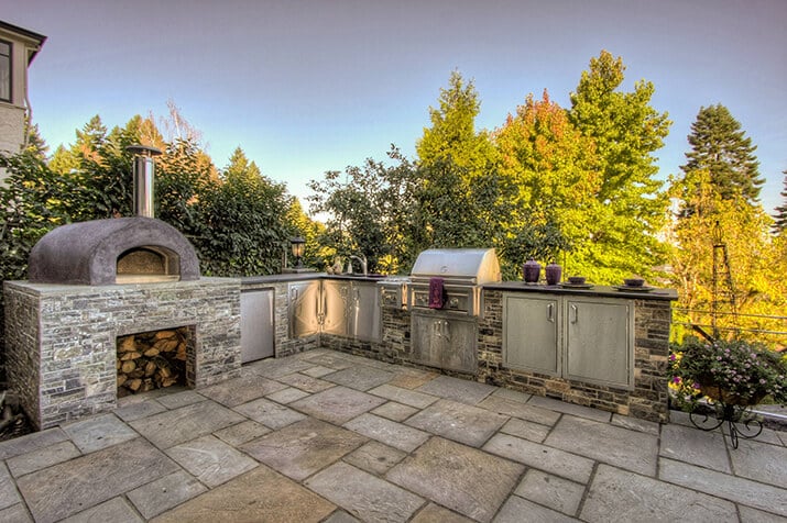Outdoor kitchen with pizza oven with a wood-oven flame.