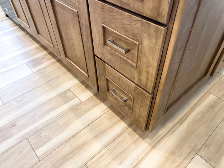 Large drawer pulls on natural wood cabinets.
