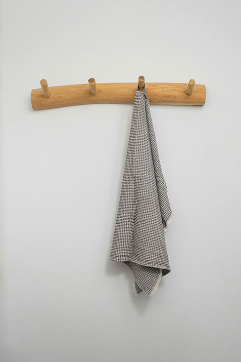 Beige towel on peg towel rack.