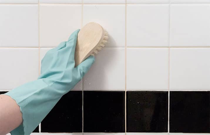 Individual scrubbing shower tile with a brush.