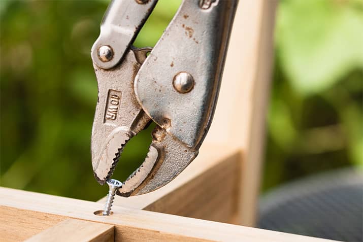 Use pliers to remove stripped screws from the wood.