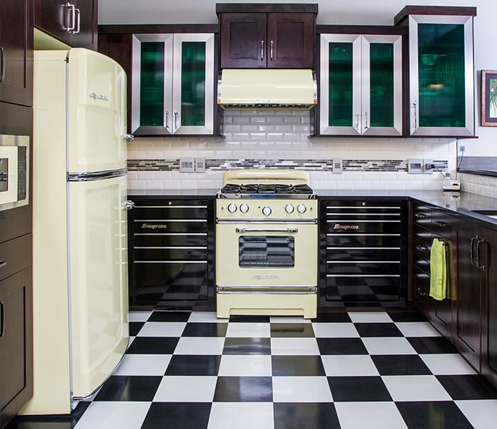 Retro kitchen with checkered floors, pastel appliances, and chrome detailing.